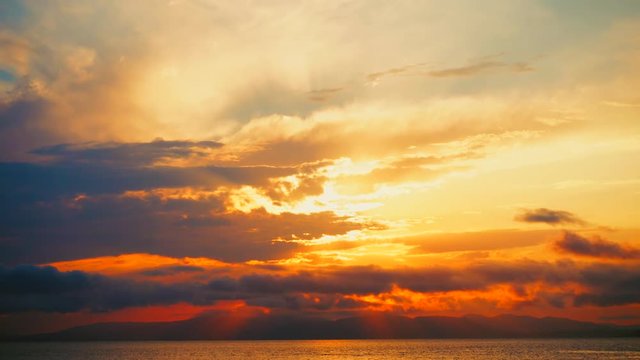 Sea view on a pleasant summer evening: a beautiful sunset, colored clouds, a pure sea with a yacht, the glint of the sun on the water. Sea, ocean, natural video for tourist, resort and meditative site