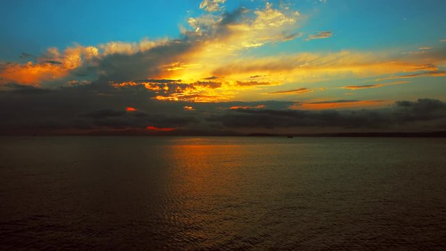 Sea view on a pleasant summer evening: a beautiful sunset, colored clouds, a pure sea with a yacht, the glint of the sun on the water. Sea, ocean, natural video for tourist, resort and meditative site