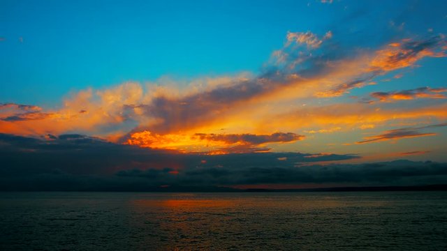 Sea view on a pleasant summer evening: a beautiful sunset, colored clouds, a pure sea with a yacht, the glint of the sun on the water. Sea, ocean, natural video for tourist, resort and meditative site