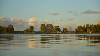Time lapse wiew of a river landscape with cumulus clouds at sunset in Latvia - Powered by Adobe