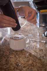 Fototapeta na wymiar Coffee shop with a girl preparing a coffee cup