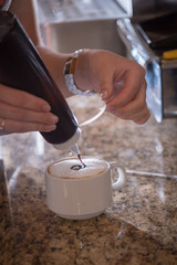 Fototapeta na wymiar Coffee shop with a girl preparing a coffee cup