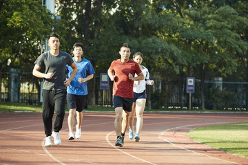 young asian adults running on track