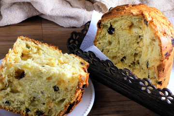 closeup panettone inside box on wooden table and slice on white plate