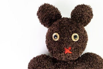 Closed up of cute handcraft fluffy brown yarn mixed between bear and bunny doll on isolated white background, pity eyes with red muted mouth with copy space