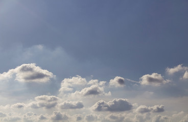 View of small clouds with a blue sky background in a sunny summer day.