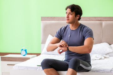 Young handsome man doing morning exercises in the hotel room