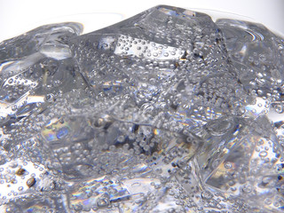 Close up of the sweet soda drink, transparent ice cubes and bubbles.Gray background. Carbonated drink is liquid beverage.  Summer cool and fresh concept. With copy space.