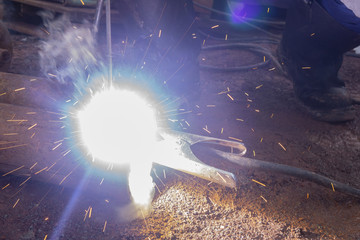 Fototapeta na wymiar Operator welding steel construction. Industrial worker during welding works