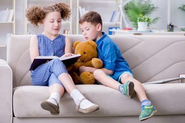 Two kids reading books at home