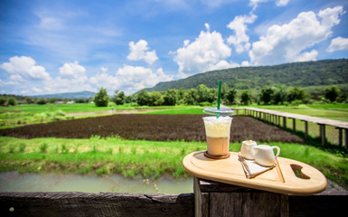 The background of the drink, (coffee, fresh milk, nectar). The back has a view of the mountains, green fields, view wooden bridge, beautiful natural and relax during the holiday.