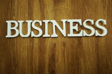 business alphabet letters top view on wooden background