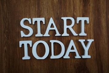 start today alphabet letters top view on wooden background