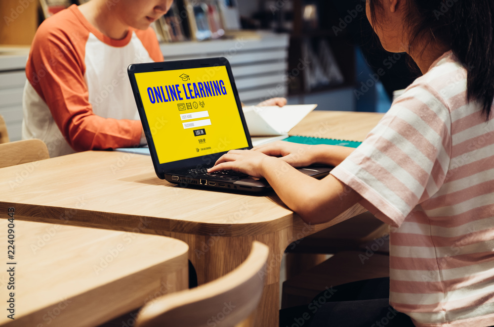 Aufkleber young asian student log in to website online learning center at table in library in school.digital age education concept.