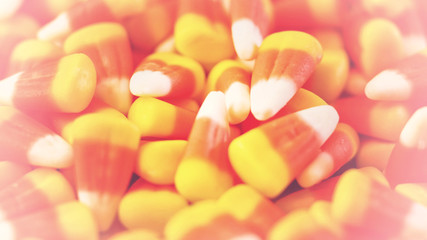 Macro closeup of Halloween traditional Candy Corn treats, retro filter background.