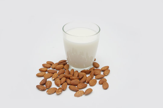 Almond milk in bottle with nuts isolated on white background