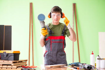 Young man carpenter working in workshop 