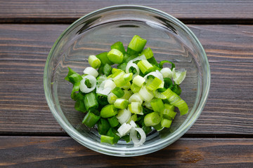 Chopped green onions in a small bowl on the kitchen counter waiting for the chef to use it as a garnish.