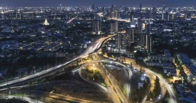 timelapse of night city traffic on 4-way stop street intersection circle roundabout in bangkok, thailand. 4K horizontal aerial view.