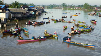 weiter Blick von Hängebrücke in Kalimantan auf schwimmenden Markt mit vielen bunten Booten in Lok...