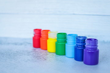 rainbow Gouache or acrylic paints in jars on white grunge background, selective focus