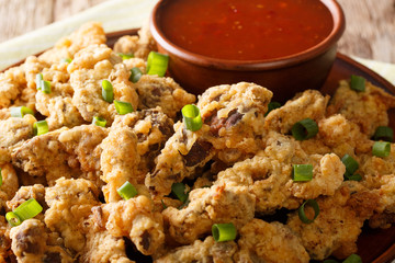 Fried chicken stomach in breaded, served with chili sauce close-up. horizontal