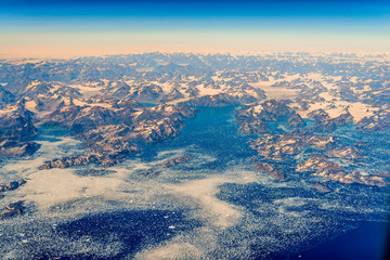 The eastern coast of Greenland on a July morning. View from the plane.