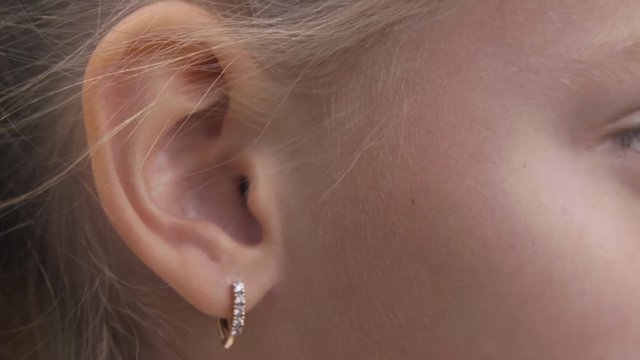 Ear and eye of young blonde girl, extreme closeup view