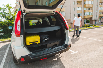man putting bags in car trunk. ready for car travel