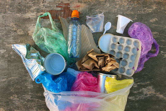 Garbage Bag With Different Trash On Wooden Background. Top View. Flat Lay.