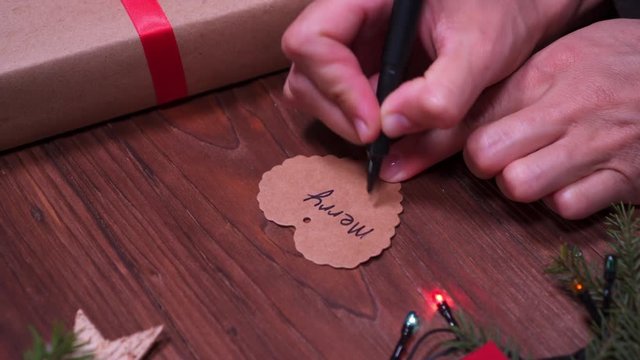 Hands writing greeting card for Christmas present