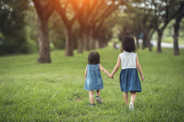 Two little sisters holding each other hands and running forward.Vintage color