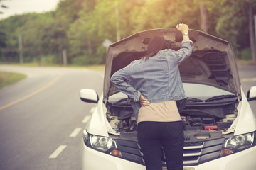 Women spection She opened the hood Broken car on the side See engines that are damaged or...
