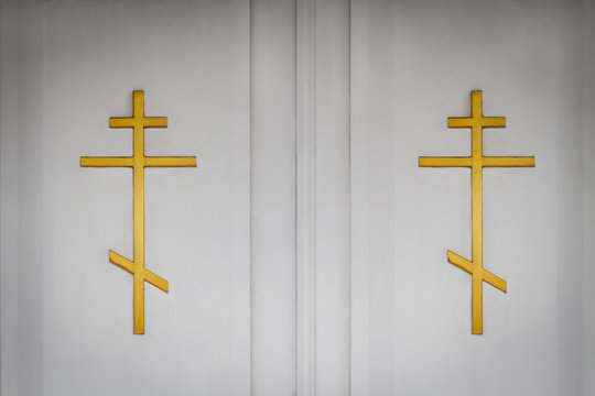 White church doors with golden orthodox crosses. Closeup