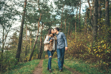 Pretty couple with little yorkshire terrier walking in the forest.