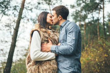 Pretty young couple walking together in the forest.