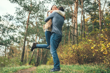 Pretty young couple walking together in the forest.