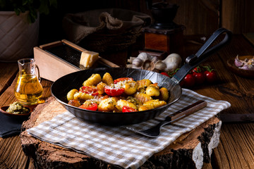 gnocchi baked with green pesto, cherry tomatoes and parmesan