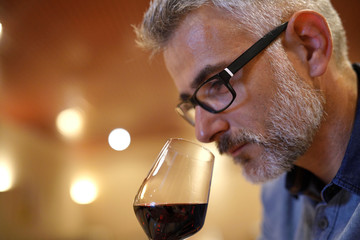 Winemaker tasting red wine in cellar