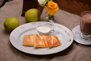 pancakes with sour cream on a white plate
