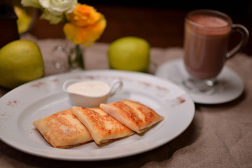 pancakes with sour cream on a white plate