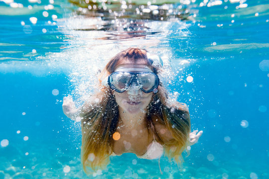 Beautiful woman underwater snorkeling in the clear tropical water