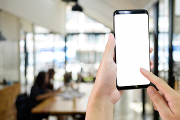 Hands using smartphone in modern office.