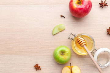 Jewish holiday Rosh Hashanah background with honey and apples on wooden table.