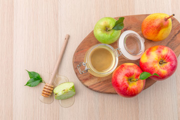 Jewish holiday Rosh Hashanah background with honey and apples on wooden table.