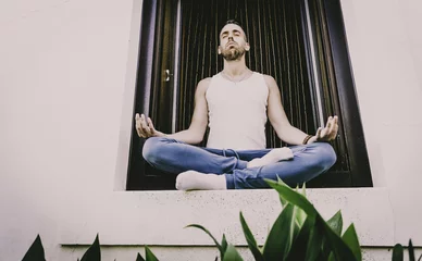 Fototapeten Lotusblume Young man practicing yoga posture called lotus flower  © Juanrastock