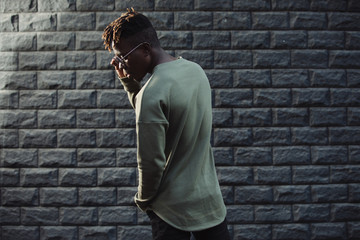 Obraz premium Man wearing fashionable pullover clothes against brick wall background