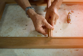 The hands of technicians who are working repair the wood.