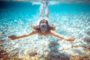 Girl snorkeling underwater in the tropical sea