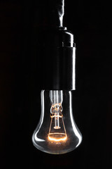 A classic Edison light bulb on dark background with space for text